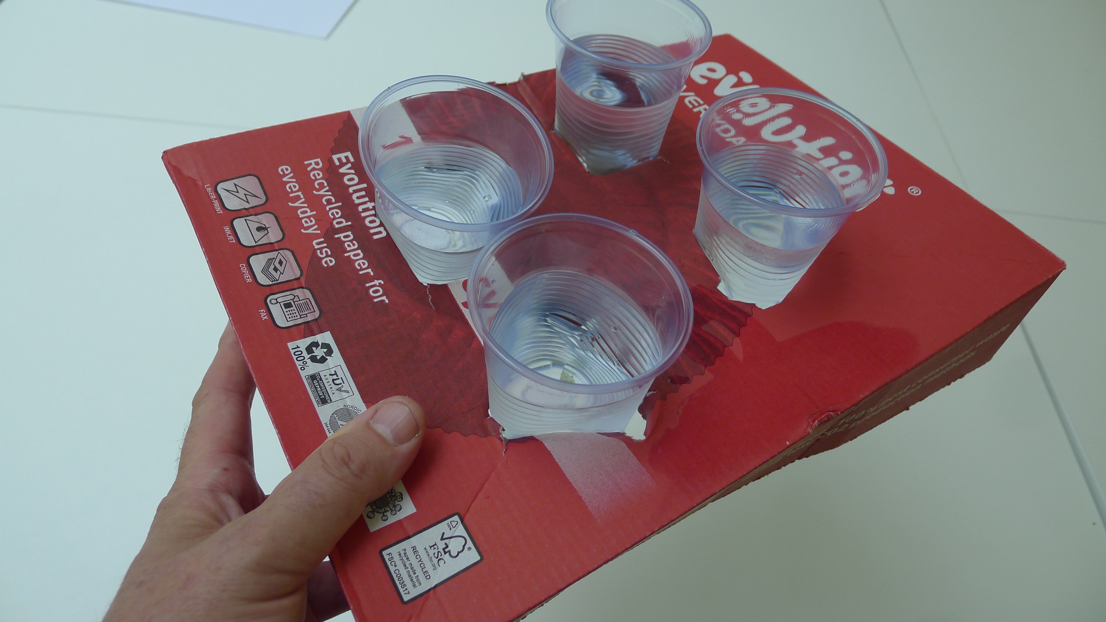 Red product packaging with clear plastic cups on a white surface